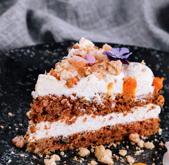 Sliced carrot cake filled and topped with cream cheese