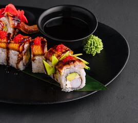 Canada roll with snow crab on black plate