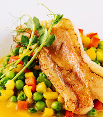 Plate with tasty baked cod fillet with vegetables