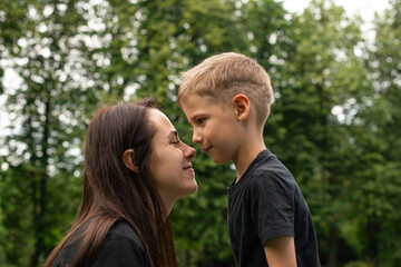 Mom and son are walking in the park and hugging