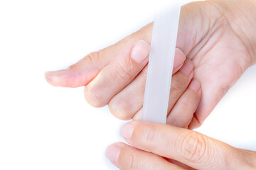 a woman puts a manicure on her hand with a nail file