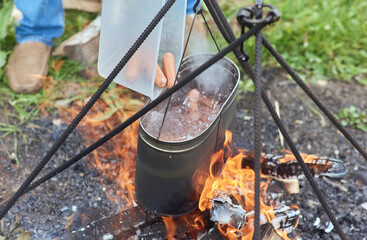 Bowler cooking food bonfire cauldron camp fire, pot. Hiking pot in the bonfire. Traveling in the...