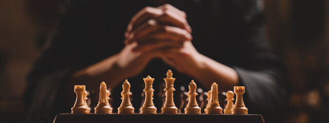 Close up hand Chess business concept. Businessman moving chess piece on chess board game for ideas...