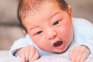 Newborn baby face down yawning