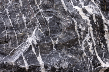 The background from the picture of a natural stone of dark blue color with white veins
