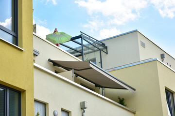 Wintergarten mit dreiseitiger Verglasung und Markise am Dachgeschoss einer Mehrfamilien-Wohnanlage