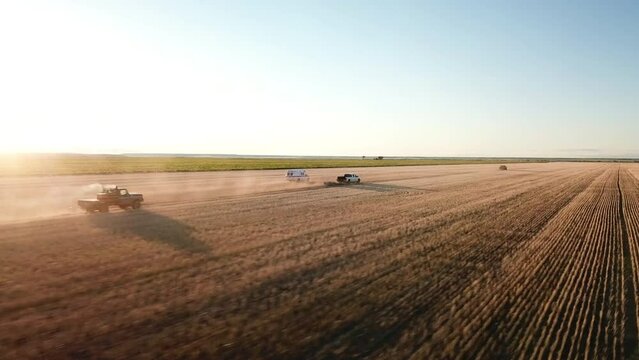 Aerial: Drone Panning Near Ambulance And Pickup Trucks Blowing Dust On Field Against Sky - Billings, Montana