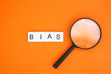 magnifying glass and letters of the alphabet with the word BIAS. inclination or prejudice for or against one person - obrazy, fototapety, plakaty