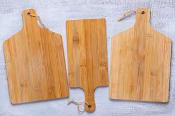 Wooden cutting boards on a light table with copy space, top view