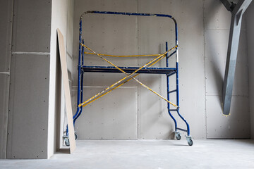 Construction mobile scaffolding is located in a room sheathed with plasterboard. Repair,...
