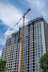 Fototapeta premium Construction site with high-rise crane. Construction of modern apartment buildings and a new residential complex. Bottom up view
