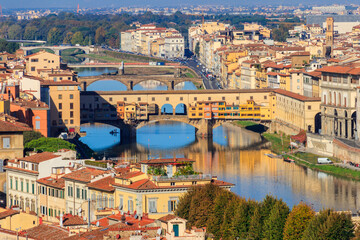 Fototapeta na wymiar Panoramic view of medieval stone bridge Ponte Vecchio over Arno river in Florence, Tuscany, Italy. View from Michelangelo Hill