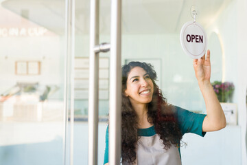 Beautiful business owner looking happy opening her shop