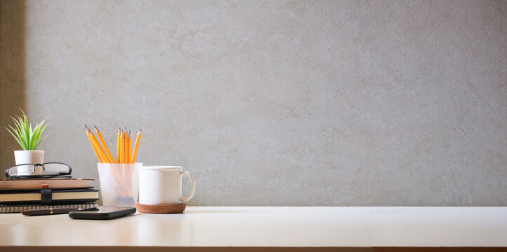 Comfortable workplace with coffee, stationery and houseplant on white table. Home office, copy space.