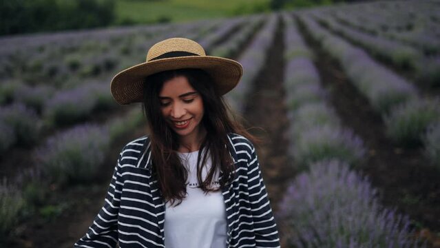 Provence, lavender field, France, Valansol plateau, colorful lavender field in Provence, women on vacation in Provence. A young attractive woman in a hat is walking in a field and enjoying the aroma