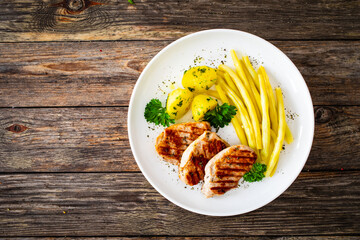 Grilled meat and yellow asparagus on wooden table
