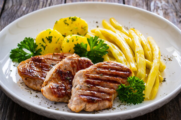 Grilled meat and yellow asparagus on wooden table
