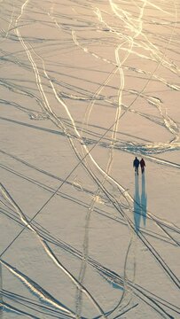 The two travelers with backpacks walking trough the snow field