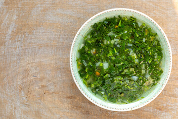 Lemon and fresh green coriander herb soup. Top view.