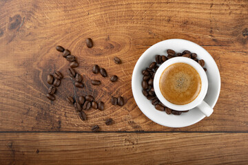 Espresso coffee cup with beans on wooden table