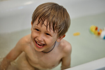 Child having fun while bathing in the bathroom