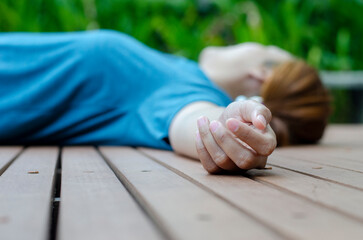 Hands of a young woman fainting in the park in the summer because of the hot weather.