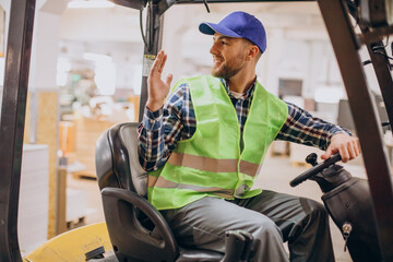 Man working at warehouse and driving forklift