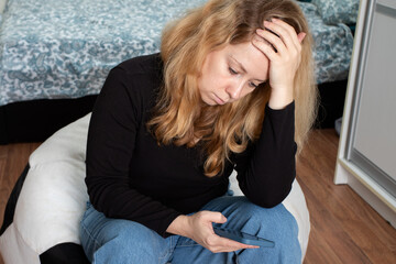 Obraz premium stress, psychosis, neurosis from news on the Internet, a woman with a phone suffers because of the war, economic crisis, exchange rates