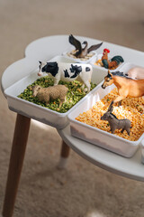 Farm animals in sensory bin. Educational game. Learning through play. Montessori material concept for toddlers. Sensory play ideas with small farm world play.