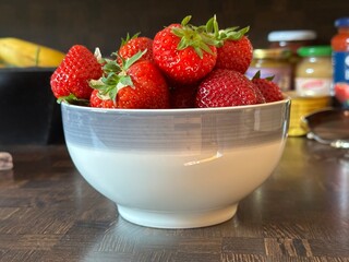 ripe large strawberries in a cup on a wooden table