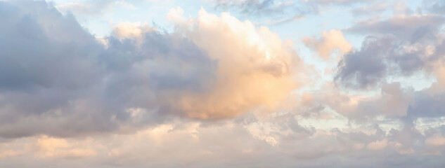 Obraz premium Beautiful fluffy clouds painted in bright painterly colors at sunrise. Banner. Multicolor nature background or wallpaper