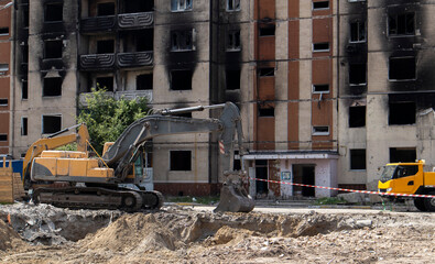 The process of demolition of the old dismantling of the building. The excavator breaks the house. Demolition of dilapidated housing. Construction digger demolishing a house for renovation.