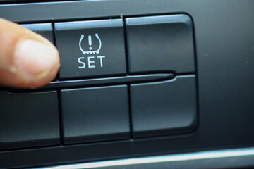 The driver presses the TPMS button to activate the TPMS feature on his car