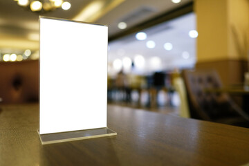 Mock up Menu frame standing on wood table in Bar restaurant cafe. space for text.