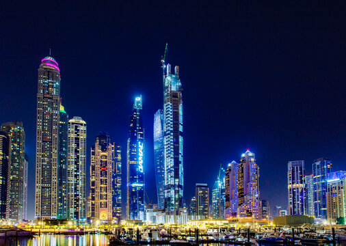 Dubai, UAE – april 09, 2023: Dubai International Marine Club, view of skyscrapers and Princess Tower, Ciel, Elite Residences Tower at night, boats and yachts