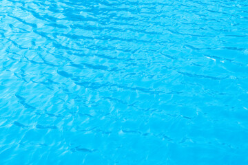 The blue surface of the pool water glistens in the sun