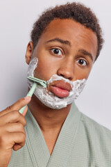 Well groomed man meticulously shaves his beard focusing on achieving clean and fresh look applies...