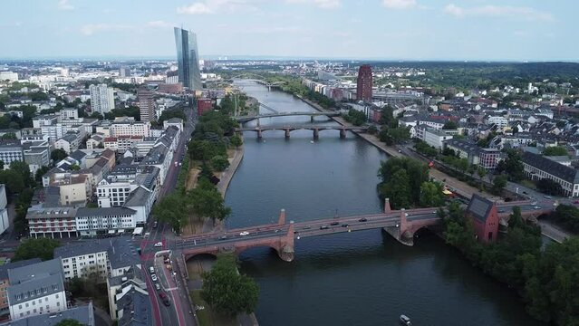 Zooming out of a section of the river Main flowing through Frankfurt, where the Floesser bridge, the Ignatz-Bubis bridge, and the old bridge can be seen.