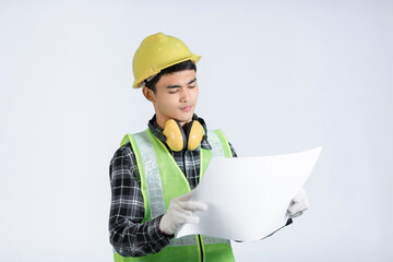 Asian young engineer wearing light green protective suit wearing a yellow hat wearing white gloves Yellow headphones, holding documents, looking solemnly examining design work. white background