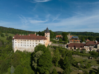 Aerial view of Vimperk Renaissance chateau castle with fortified round gun tower above the medieval town with blue sky