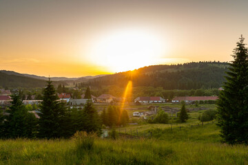  Scenic sunset over the small hungarian village, called Comandau in romanian, Kommando in hungarian in Romania, visible lens flare.