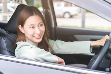 Transport, happy smile brunette hair asian young woman hand holding steering wheel driving car, vehicle for travel trip, sits on driver seat, female with fasten safety seat belt before traveling.