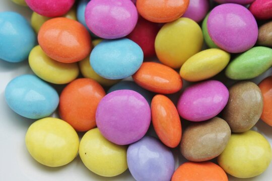 Multi colored candy coated chocolate button sprinkle texture - marties, sprinkles