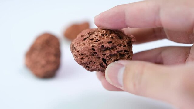 geologist holds rare minerals or copper found in a mine for examination and consideration in the lab.