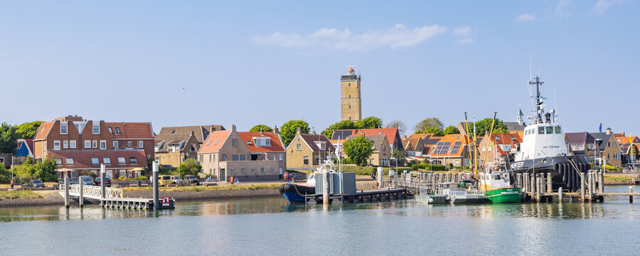 Cityscape West-Terschelling with tugboat Hunter in the harbor and Brandaris at Wadden island Terschelling in Friesland province in The Netherlands