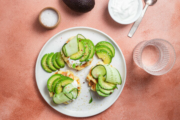 Waffles with cream cheese, avocado and cucumber on a plate