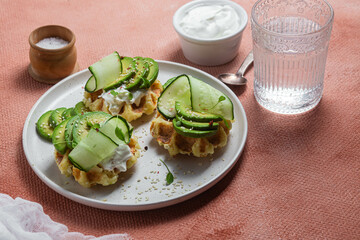 Waffles with cream cheese, avocado and cucumber on a plate