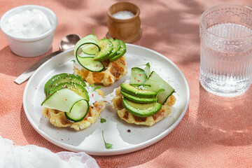 Waffles with cream cheese, avocado and cucumber on a plate
