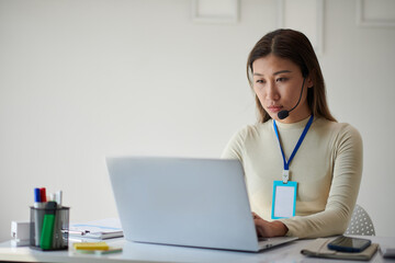 Serious company representative working on laptop in company office