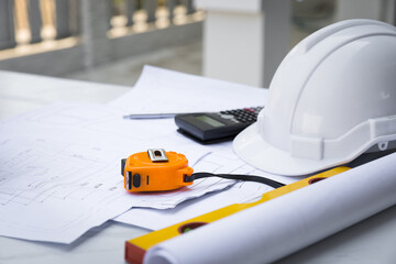 Yellow Measurement tool with white safety helmet, calculator, blueprint and equipment on table in office worker conference site with copy space. Engineering tools concept. architectural concept.